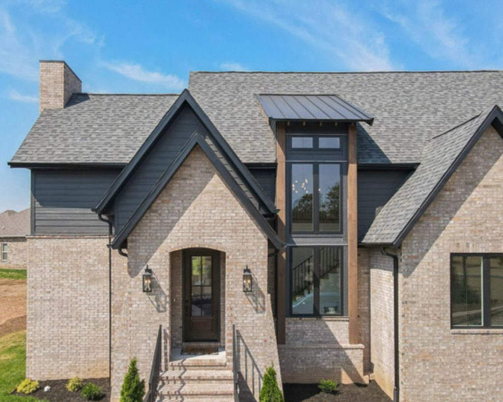 The tall entryway and tall windows on this brick, custom home gives a luxurious curb appeal